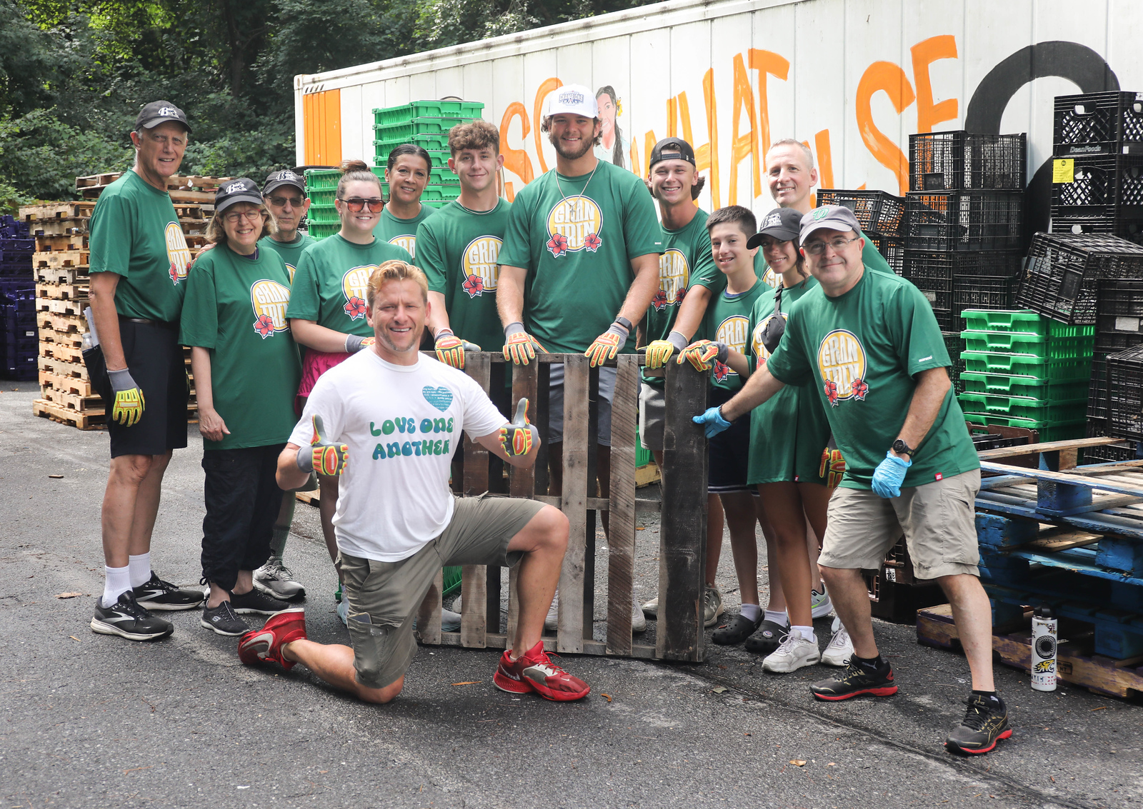 A group of people in Big Train shirts stand in front of a truck. 